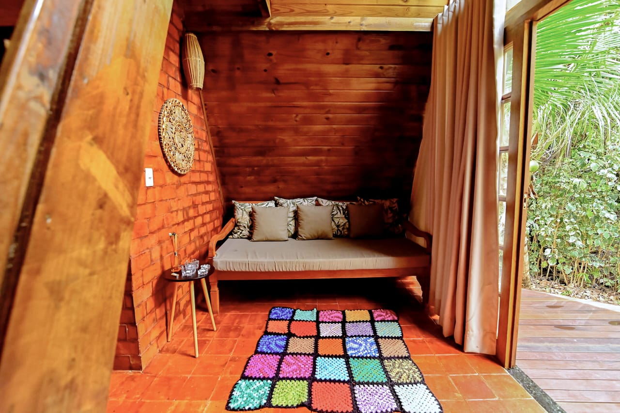Sala da Cabana Esmeralda com sofá encostado na parede de tijolo