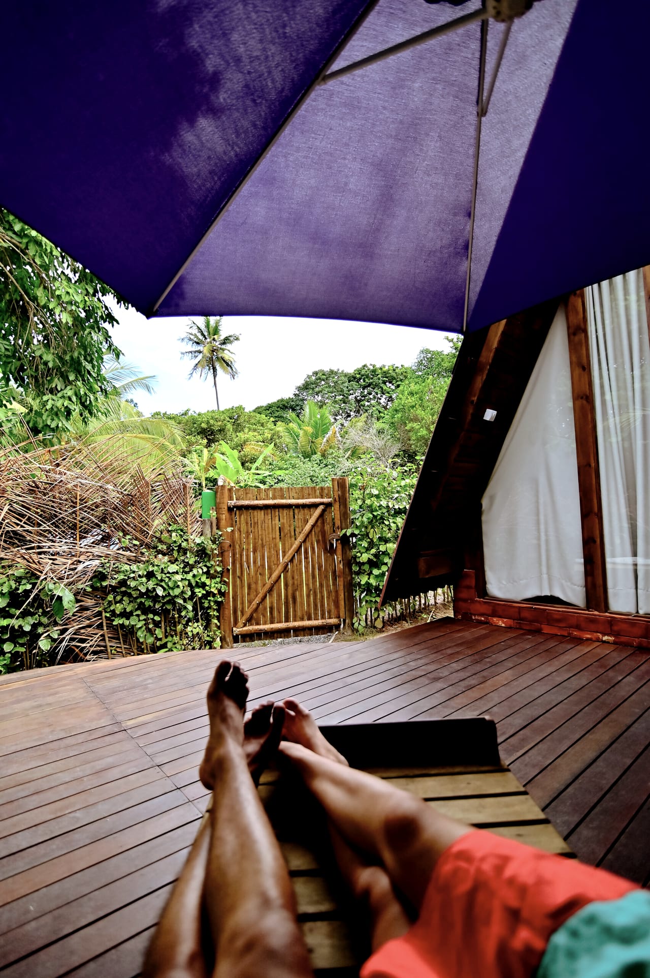 Vista do deck para o jardim, com os pés de quem descansa em primeiro plano