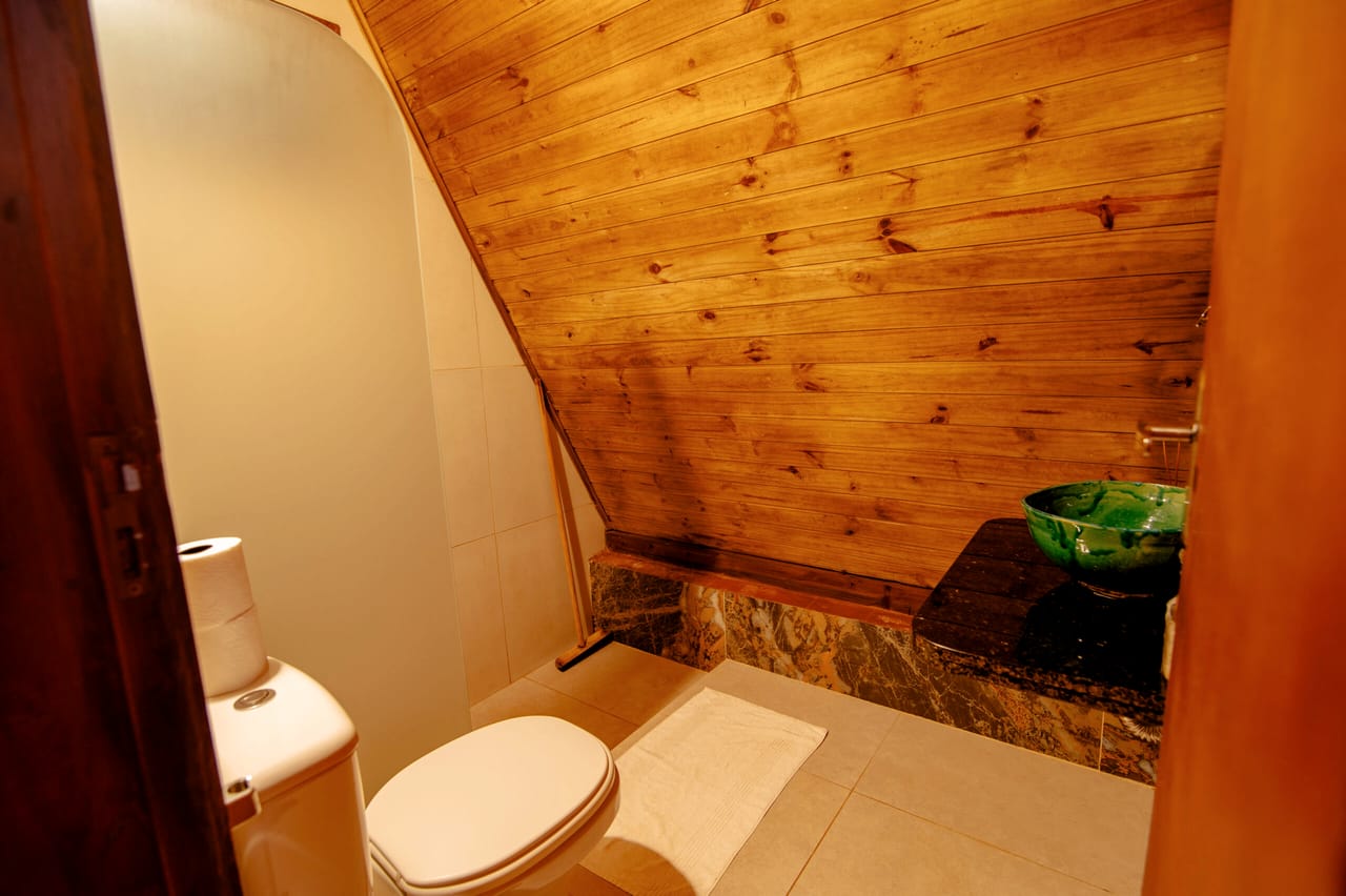 Banheiro da cabana, revestido de madeira