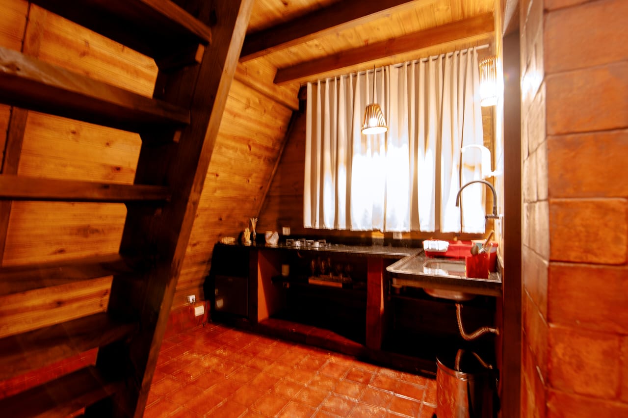A cozinha da cabana à noite, com a luz acesa