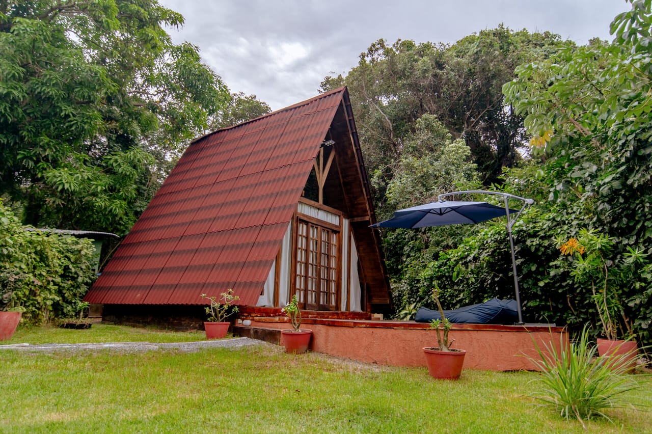 Cabana Rubi vista de fora, com o telhado triangular de telhas e o deck na frente
