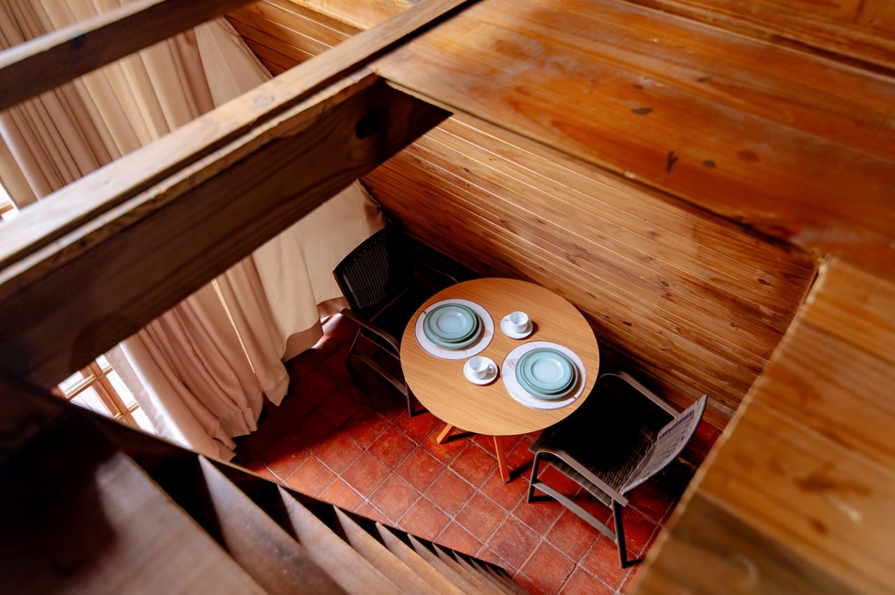 Cantinho com mesa e cadeiras dentro da cabana