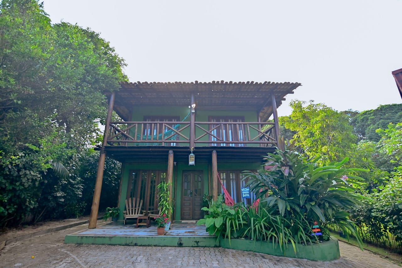 Bangalô Safira, casa de madeira verde de dois andares com varandas