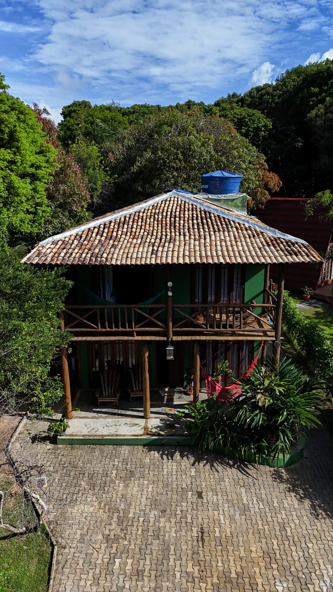Bangalô Safira, casa de madeira verde de dois andares vista da frente