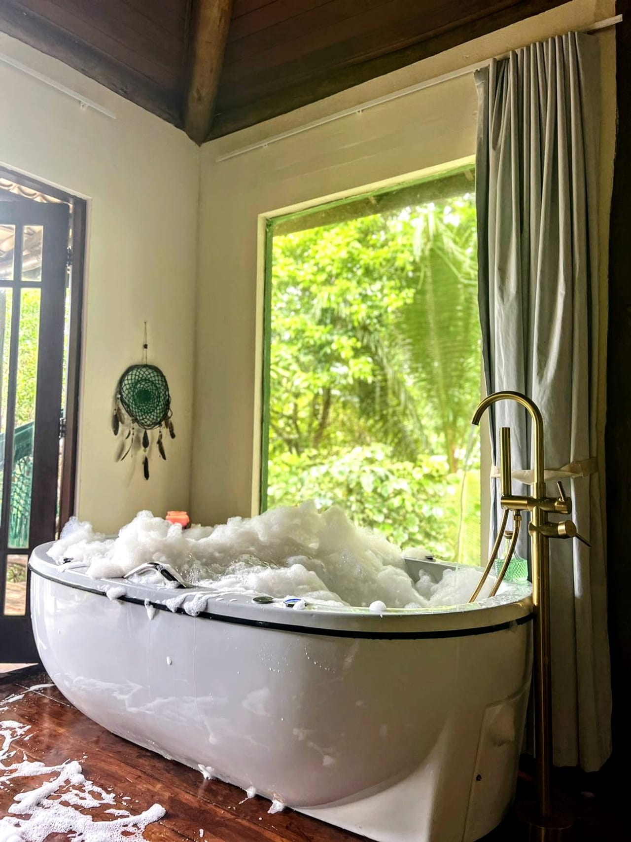 Banheira de hidromassagem cheia de espuma, com vista para o verde
