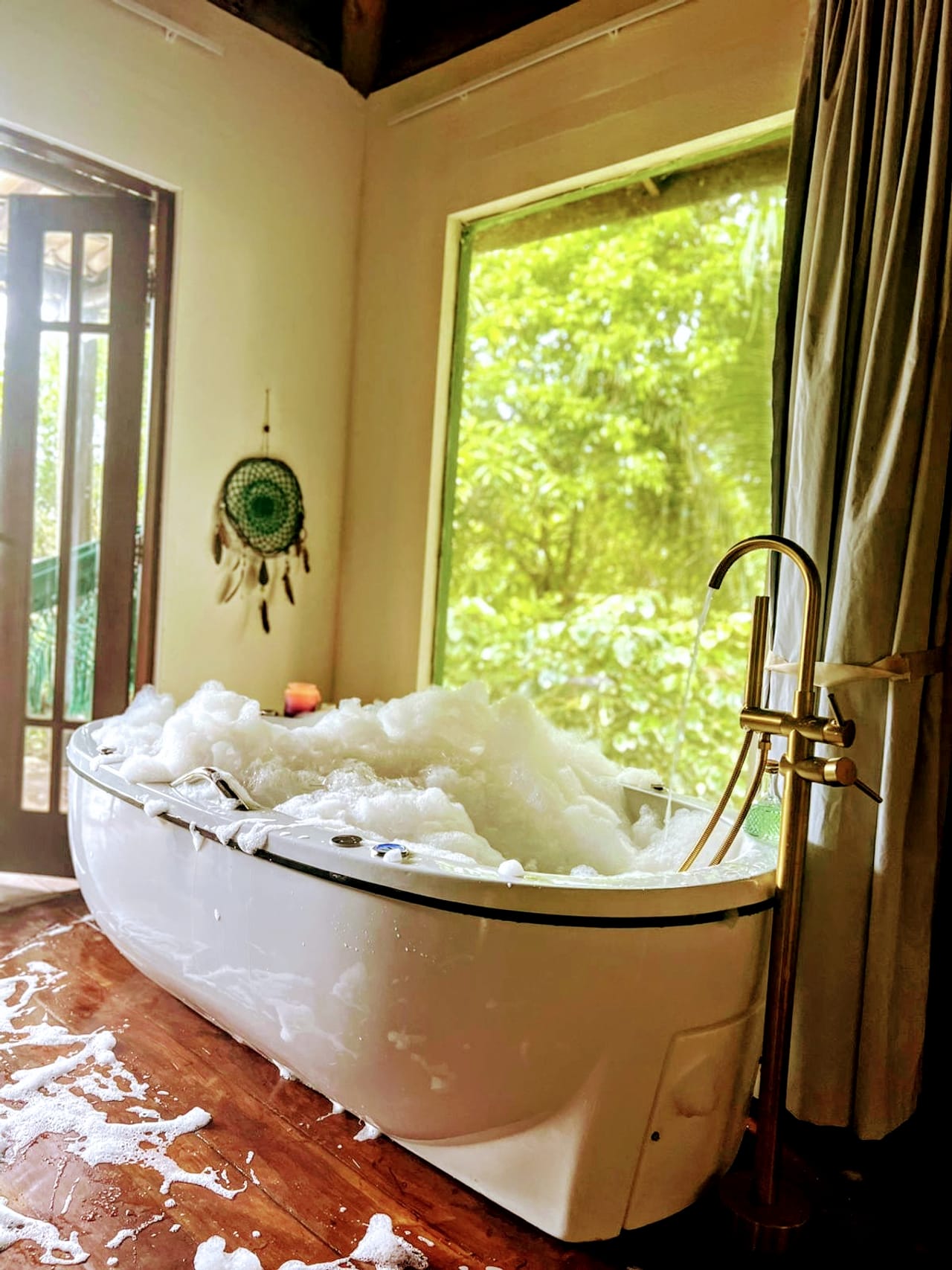 A jacuzzi cheia, com a janela aberta para as árvores