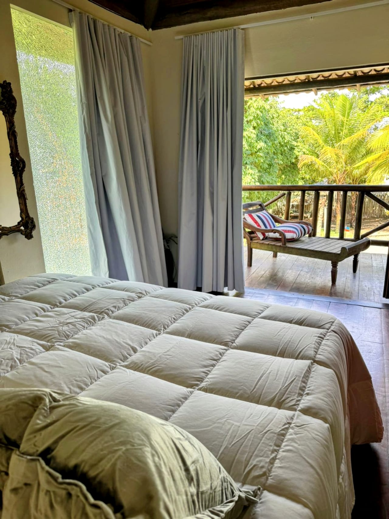 Cama de casal do quarto, com a porta aberta para a varanda