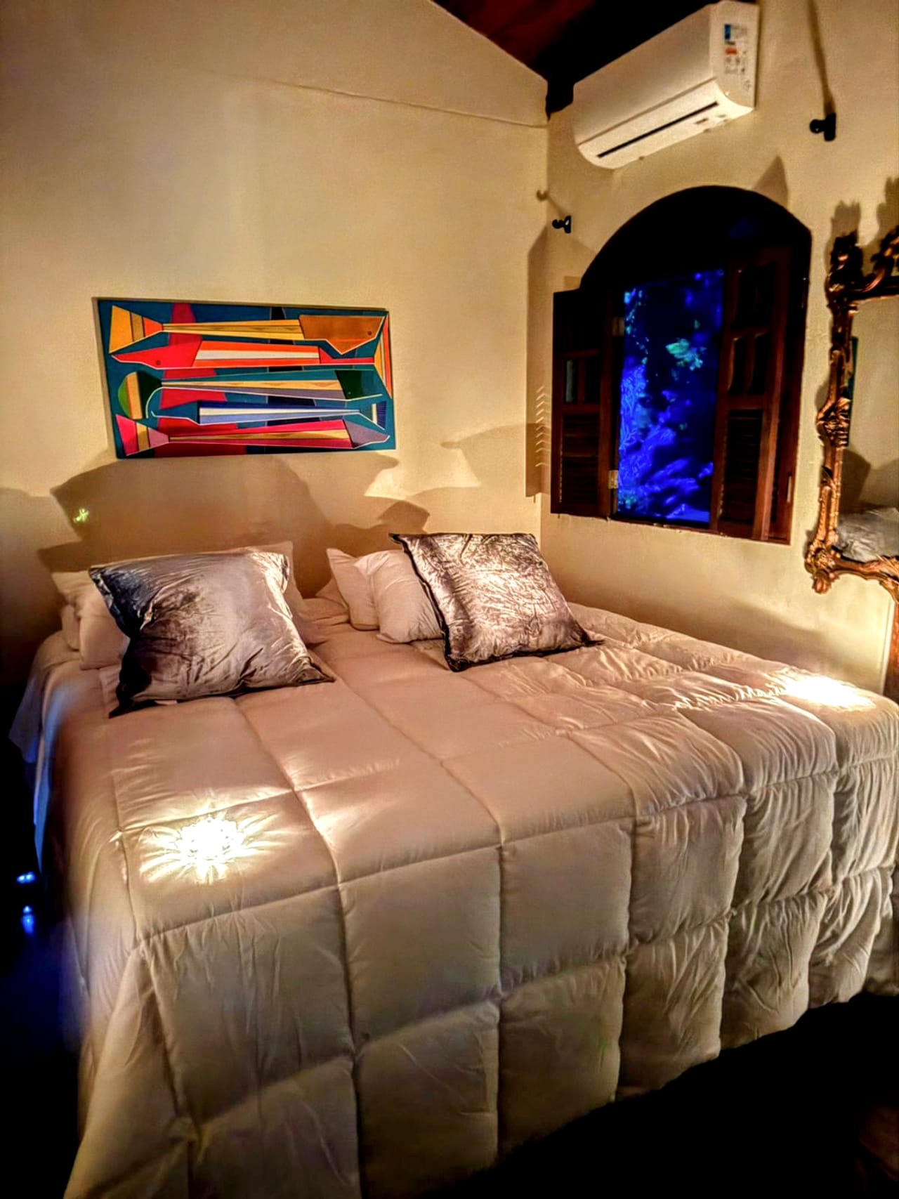 O segundo quarto, com quadro colorido acima da cama
